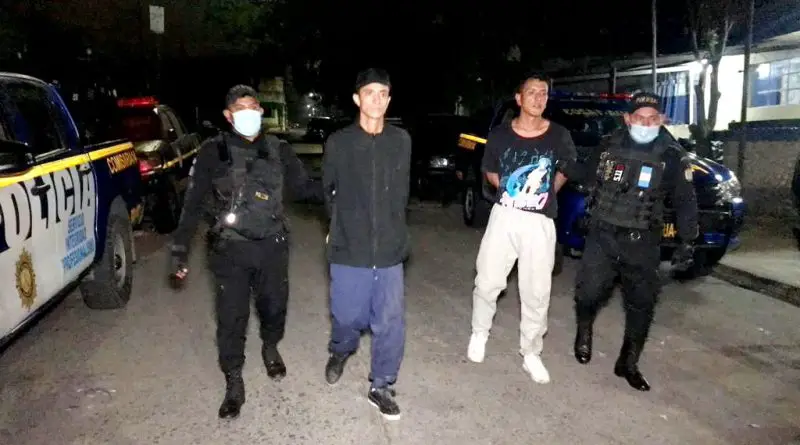 Foto de agentes de la PNC con dos sicarios capturados