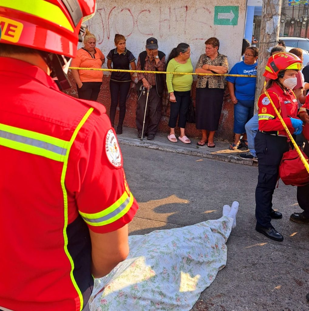 Víctima del asesino Fredy Alexander Rivera Alay, cadáver tirado rodeado de bomberos.