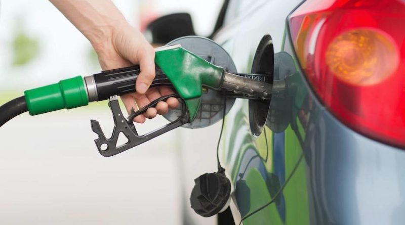 una persona echando gasolina a su carro.